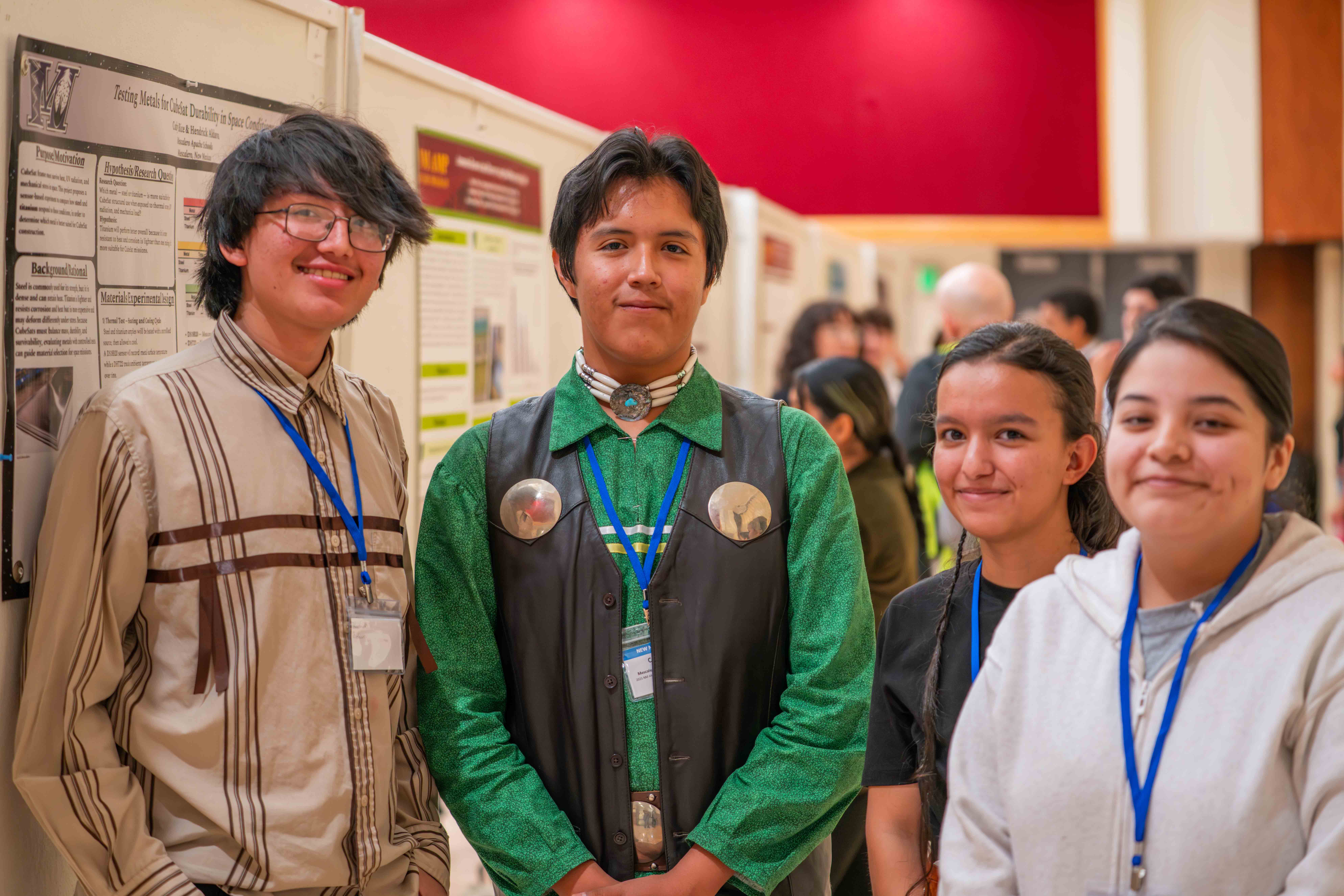 students standing in front of poster presentations at the 2025 NM AMP conference